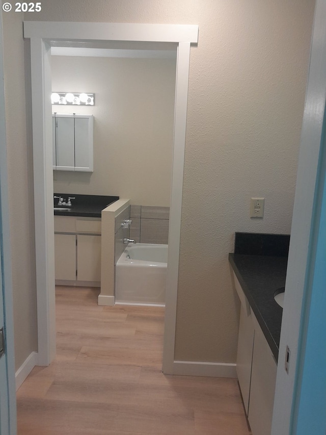 4810 SW 48th Ct, Lincoln City, OR 97367 - full bathroom with vanity, wood finished floors, a bath, and baseboards