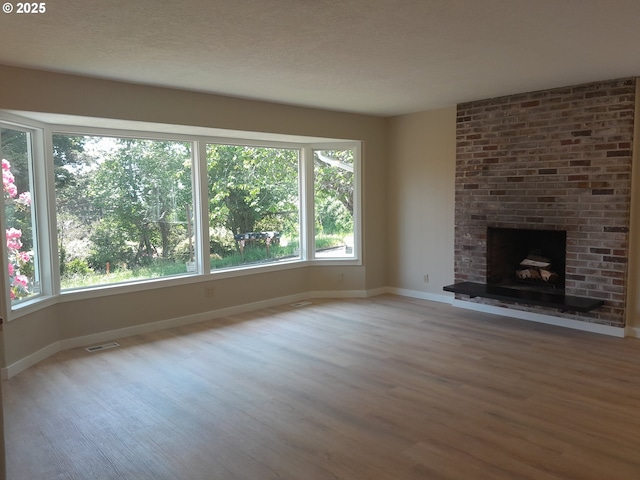 4810 SW 48th Ct, Lincoln City, OR 97367 - unfurnished living room featuring wood finished floors, baseboards, and a brick fireplace