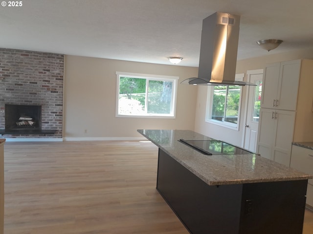 4810 SW 48th Ct, Lincoln City, OR 97367 - kitchen with island range hood, black electric stovetop, light wood-type flooring, a kitchen island, and open floor plan