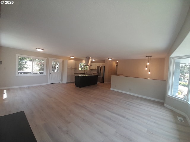 4810 SW 48th Ct, Lincoln City, OR 97367 - unfurnished living room with baseboards, light wood-type flooring, and healthy amount of natural light
