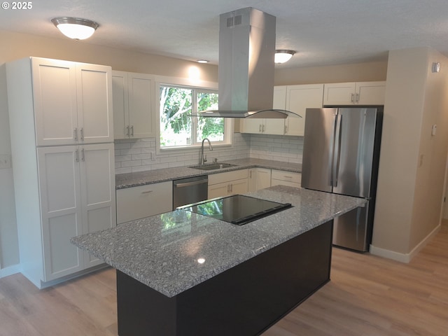 4810 SW 48th Ct, Lincoln City, OR 97367 - kitchen featuring island exhaust hood, appliances with stainless steel finishes, a sink, baseboards, and light wood-style flooring