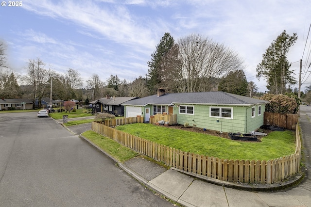 ranch-style home with a front lawn, fence, a garage, and a residential view