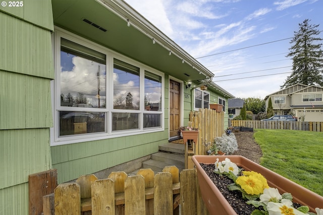 view of property exterior with fence and a lawn