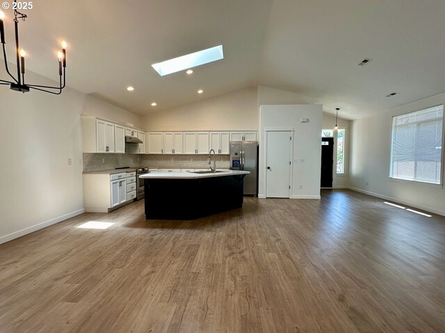 1916 SW 6th St, Battle Ground, WA 98604 - kitchen featuring stainless steel appliances, open floor plan, vaulted ceiling, wood finished floors, and a kitchen island with sink