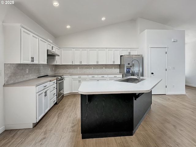 1916 SW 6th St, Battle Ground, WA 98604 - kitchen with appliances with stainless steel finishes, under cabinet range hood, a kitchen island with sink, tasteful backsplash, and white cabinetry