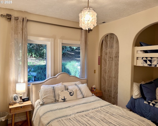 35445 Topping Rd, Pacific City, OR 97135 - bedroom featuring arched walkways and a notable chandelier