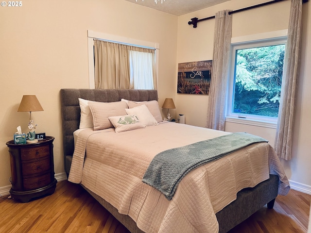 bedroom featuring baseboards and wood finished floors