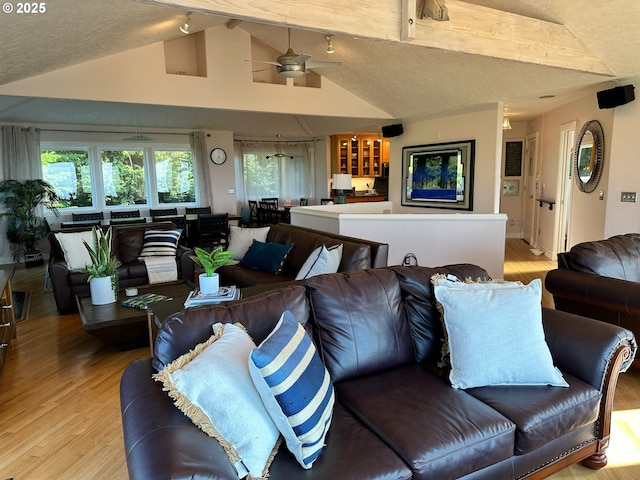 living room with light wood finished floors, ceiling fan, and lofted ceiling