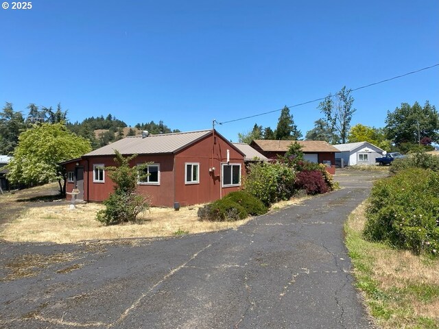 1223 NE Locust St, Oakland, OR 97462 - view of front of property with asphalt driveway and metal roof
