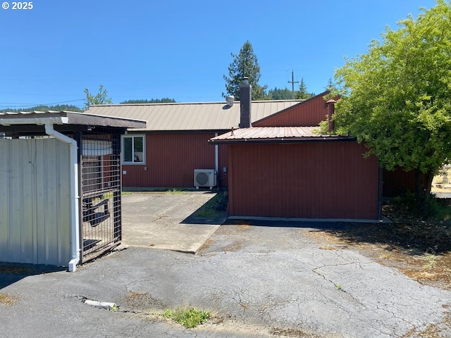 1223 NE Locust St, Oakland, OR 97462 - view of home's exterior with metal roof, a cooling unit, and an outbuilding