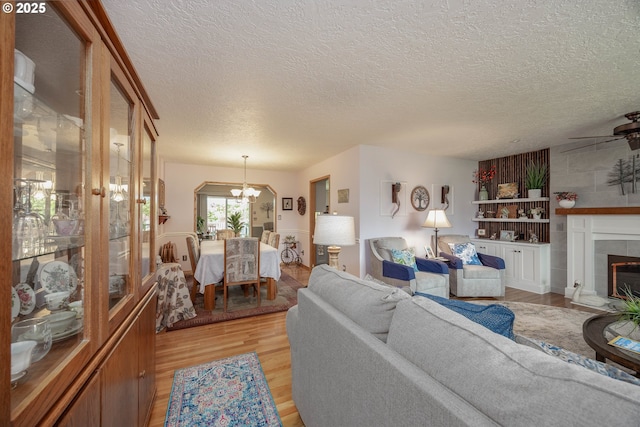 4405 NE 29th Ave, Vancouver, WA 98663 - living room with a chandelier, light wood-type flooring, a textured ceiling, and a tile fireplace