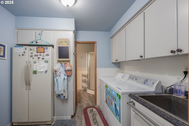 4405 NE 29th Ave, Vancouver, WA 98663 - laundry room with separate washer and dryer, cabinet space, wood finished floors, and a textured ceiling