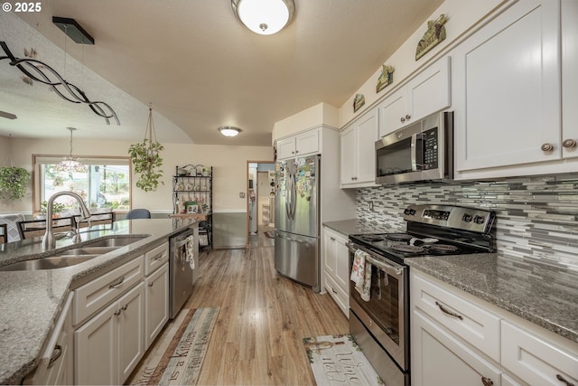 4405 NE 29th Ave, Vancouver, WA 98663 - kitchen featuring appliances with stainless steel finishes, light wood finished floors, backsplash, stone counters, and a textured ceiling