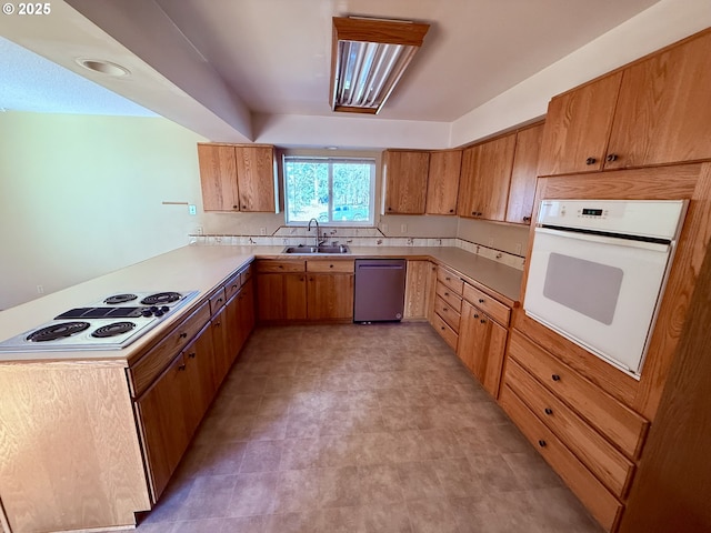 kitchen featuring sink, white appliances, and kitchen peninsula