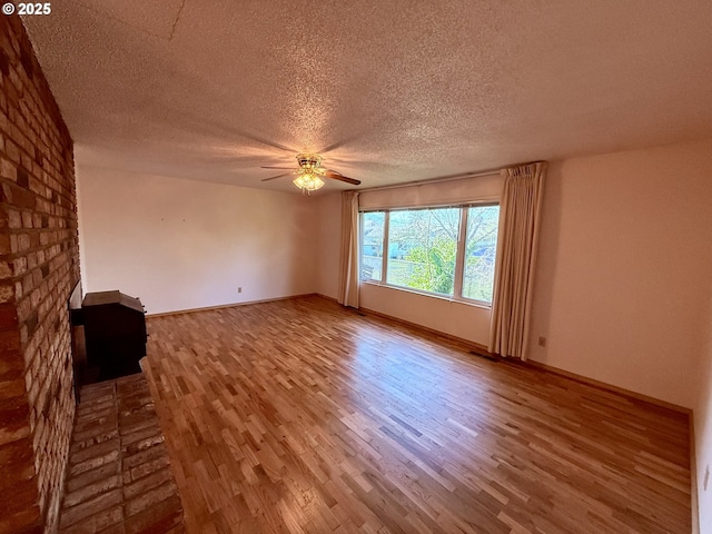 unfurnished living room featuring ceiling fan, a textured ceiling, and hardwood / wood-style floors