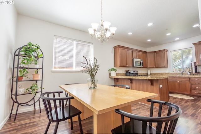 5065 SW 207th Pl, Beaverton, OR 97078 - kitchen featuring stainless steel appliances, dark wood-style flooring, recessed lighting, a kitchen breakfast bar, and brown cabinets