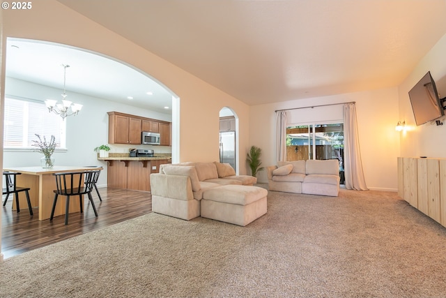 5065 SW 207th Pl, Beaverton, OR 97078 - carpeted living room featuring a chandelier, arched walkways, healthy amount of natural light, wood finished floors, and recessed lighting