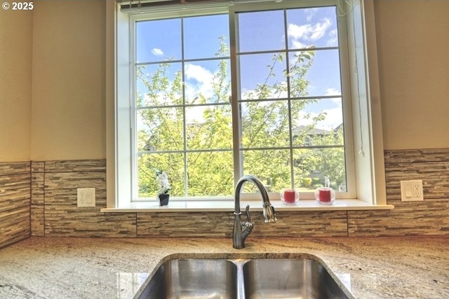interior details with light stone counters, tasteful backsplash, and a sink