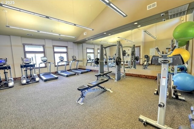 gym with lofted ceiling and visible vents