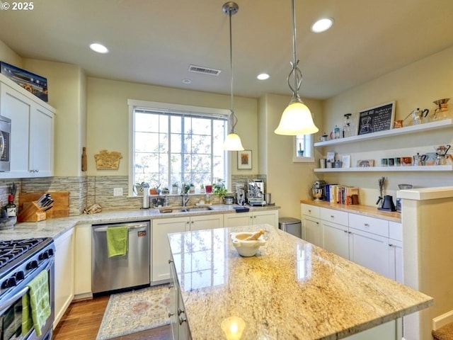 kitchen with plenty of natural light, stainless steel appliances, visible vents, and a sink