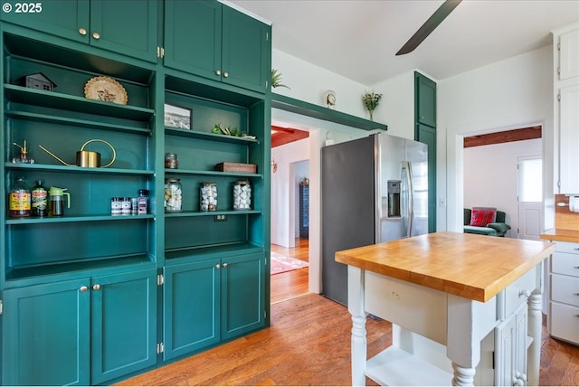 kitchen with stainless steel fridge, butcher block counters, ceiling fan, light wood-style flooring, and green cabinetry