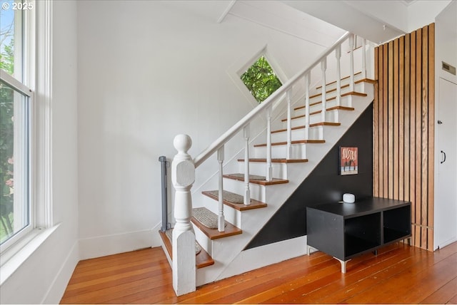 stairs featuring wood-type flooring, visible vents, and baseboards