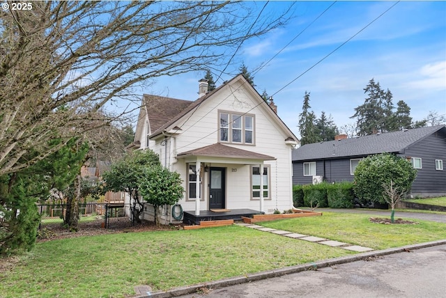 view of front of property featuring a front yard, roof with shingles, fence, and a chimney