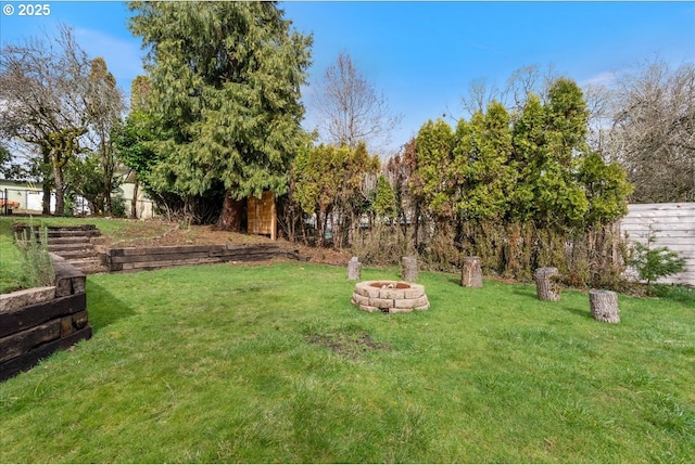 view of yard with a fire pit and fence