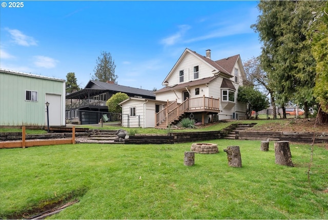 view of yard with an outdoor fire pit, fence, an outdoor structure, a wooden deck, and stairs