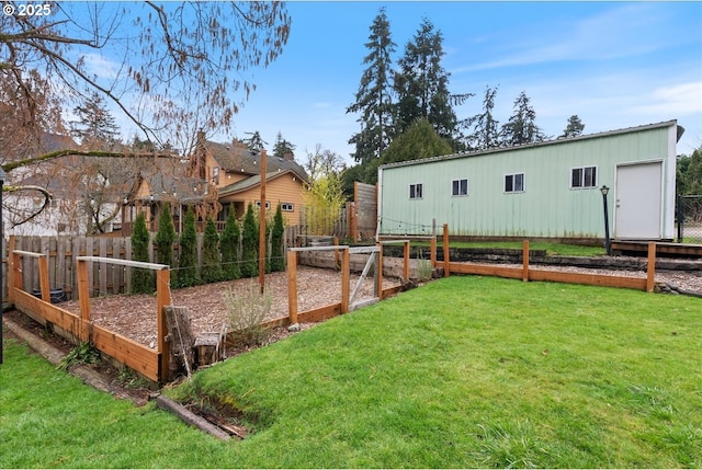 view of yard with a garden, fence, an outbuilding, and an outdoor structure