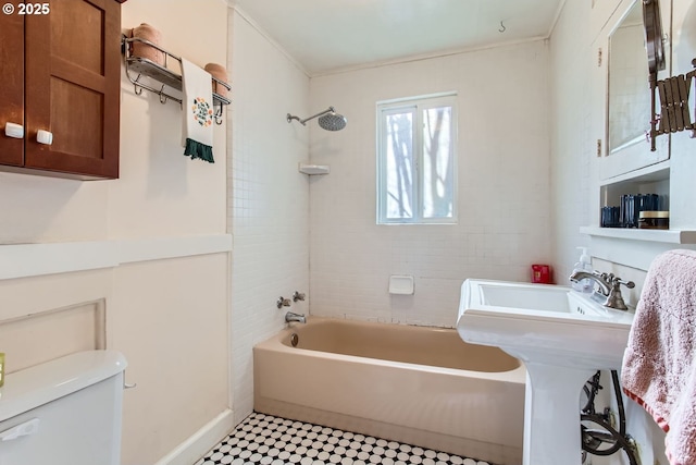 bathroom with tiled shower / bath combo and toilet