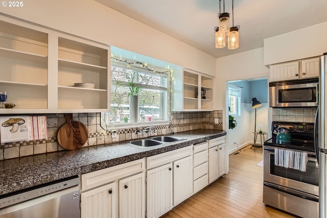 kitchen featuring stainless steel appliances, sink, pendant lighting, a healthy amount of sunlight, and decorative backsplash