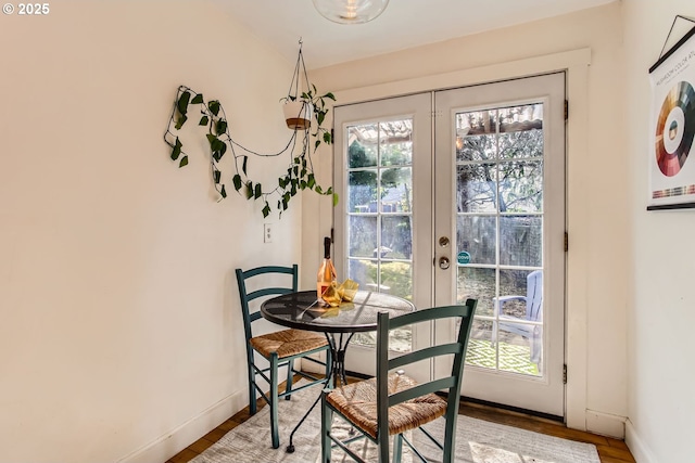 dining room featuring hardwood / wood-style flooring, a healthy amount of sunlight, and french doors