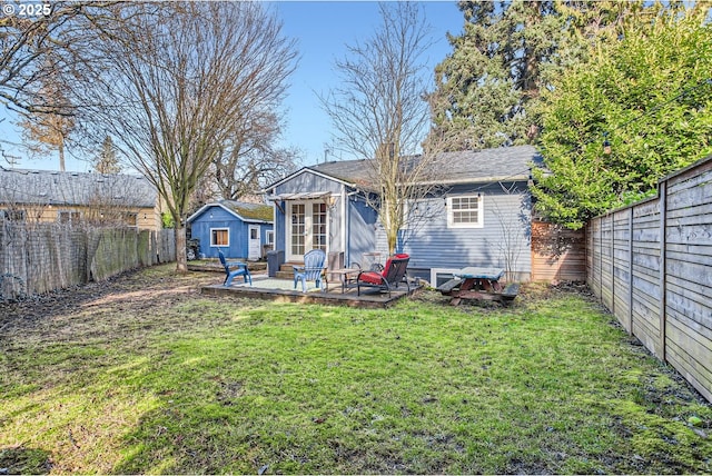 rear view of house with an outdoor structure and a lawn