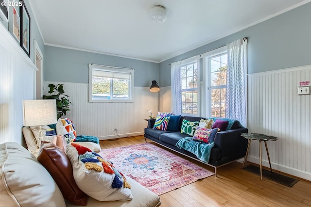 living room with light hardwood / wood-style flooring and ornamental molding