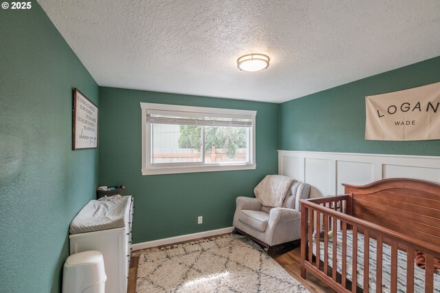 2261 Fulton Pl SE, Albany, OR 97322 - bedroom with a textured ceiling, a nursery area, and wood finished floors