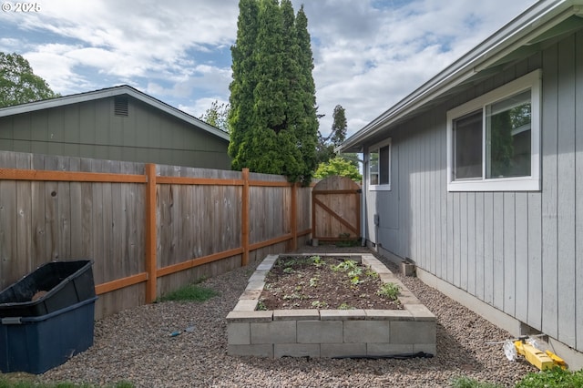 2261 Fulton Pl SE, Albany, OR 97322 - fenced backyard featuring a vegetable garden and a gate