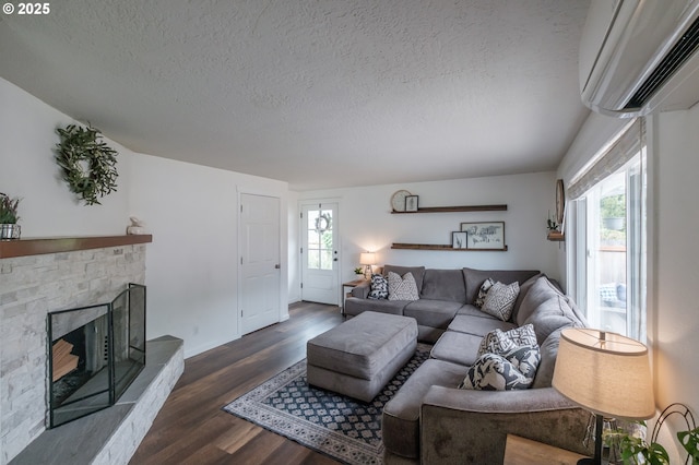 2261 Fulton Pl SE, Albany, OR 97322 - living room with an AC wall unit, a textured ceiling, dark wood-type flooring, a fireplace with raised hearth, and baseboards