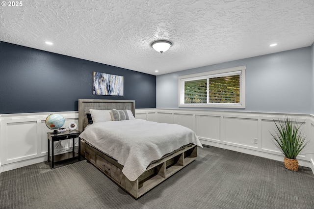 bedroom featuring dark colored carpet and a textured ceiling