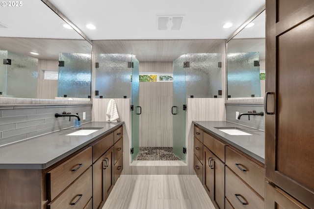 bathroom with vanity, a shower with door, and backsplash