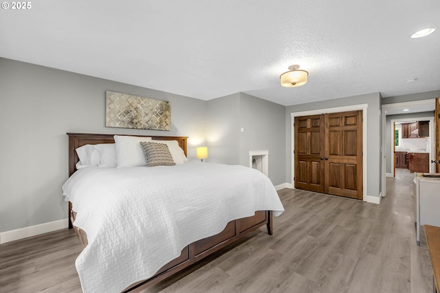 bedroom featuring light hardwood / wood-style floors, a closet, and a textured ceiling