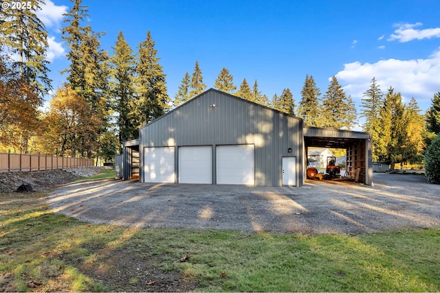 garage with a detached garage and fence