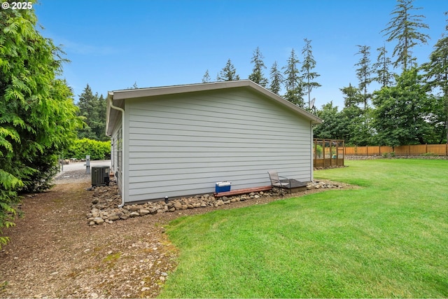 view of side of property featuring central AC and a lawn