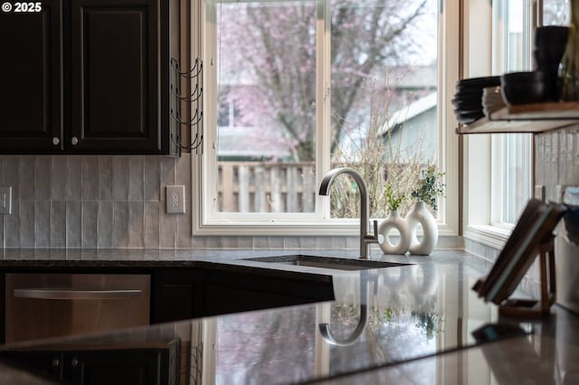 room details with dark stone countertops, a sink, decorative backsplash, a warming drawer, and dark cabinets