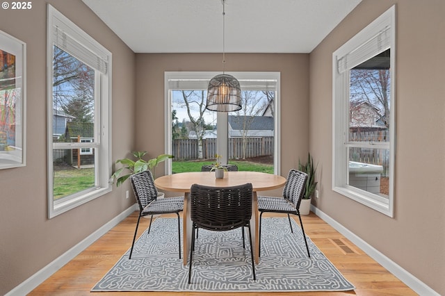 dining room featuring visible vents, light wood-style flooring, and baseboards