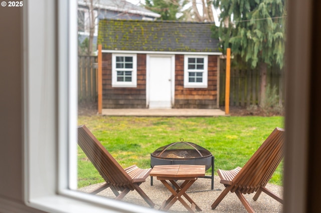 view of outdoor structure with a fire pit, an outdoor structure, and fence