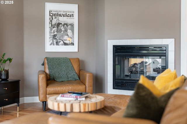 interior space featuring wood finished floors, a multi sided fireplace, and baseboards