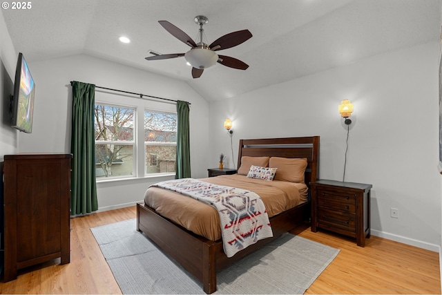 bedroom with lofted ceiling, light wood-style floors, baseboards, and ceiling fan