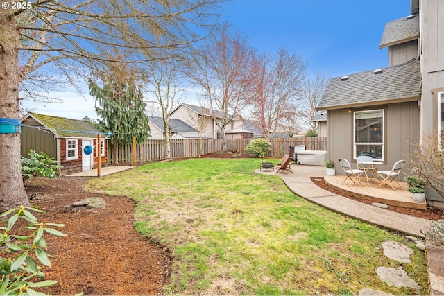 view of yard featuring an outbuilding, a fenced backyard, and a patio area