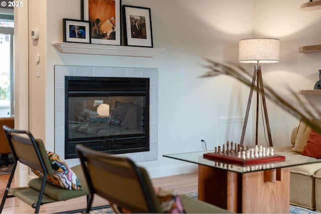 room details featuring a fireplace, baseboards, and wood finished floors